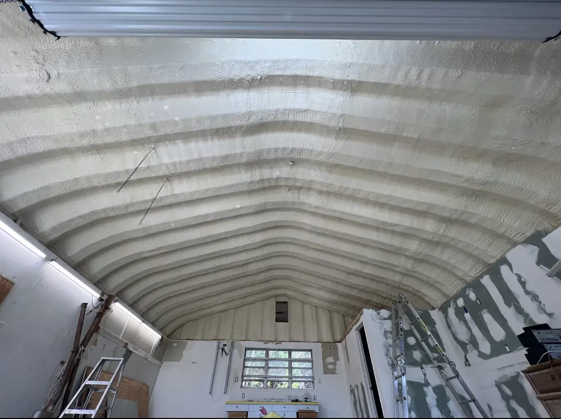 Spray polyurethane foam applied to the underside of a metal roof deck in Noble